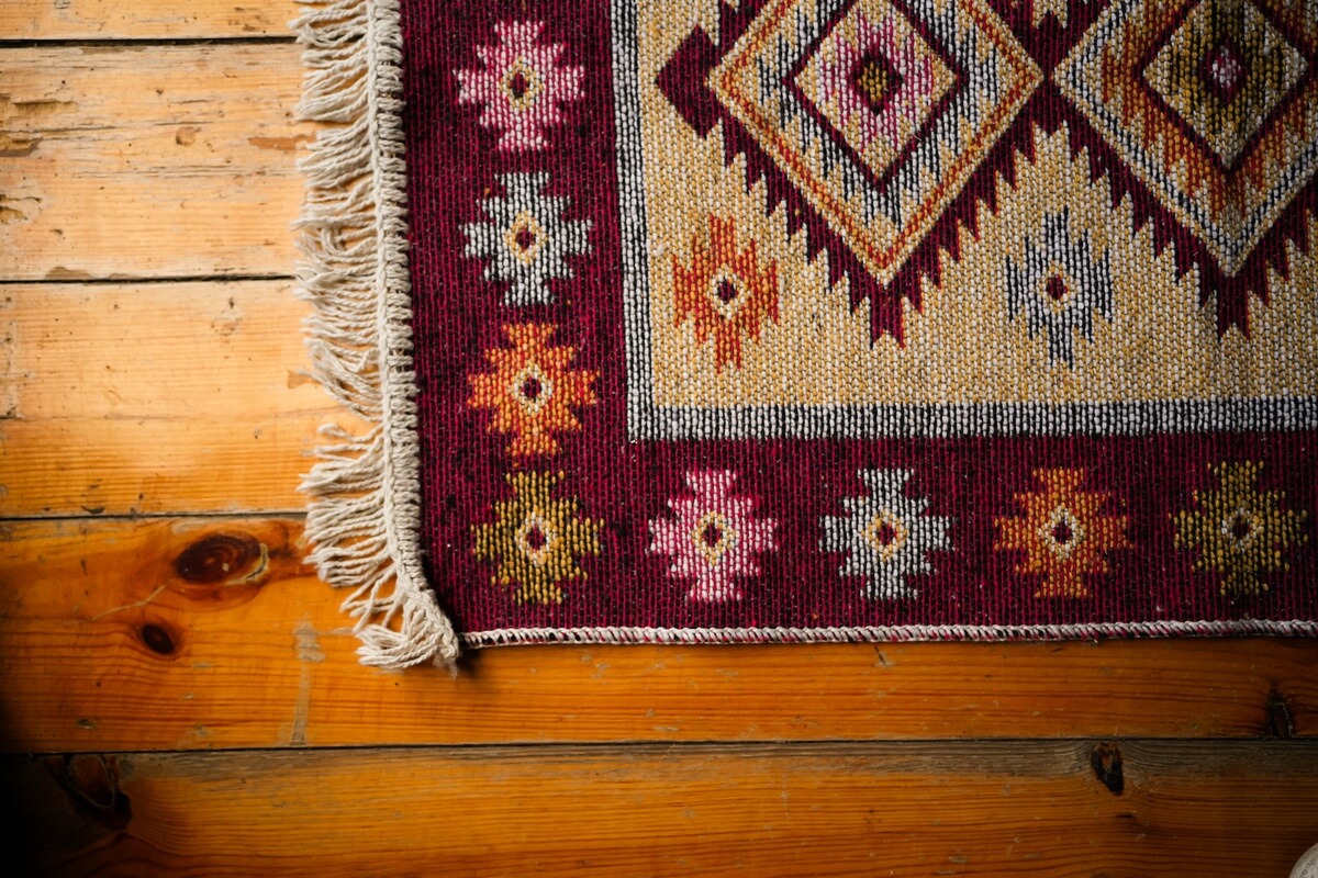 Kolorowy dywan z frędzlami na drewnianej podłodze