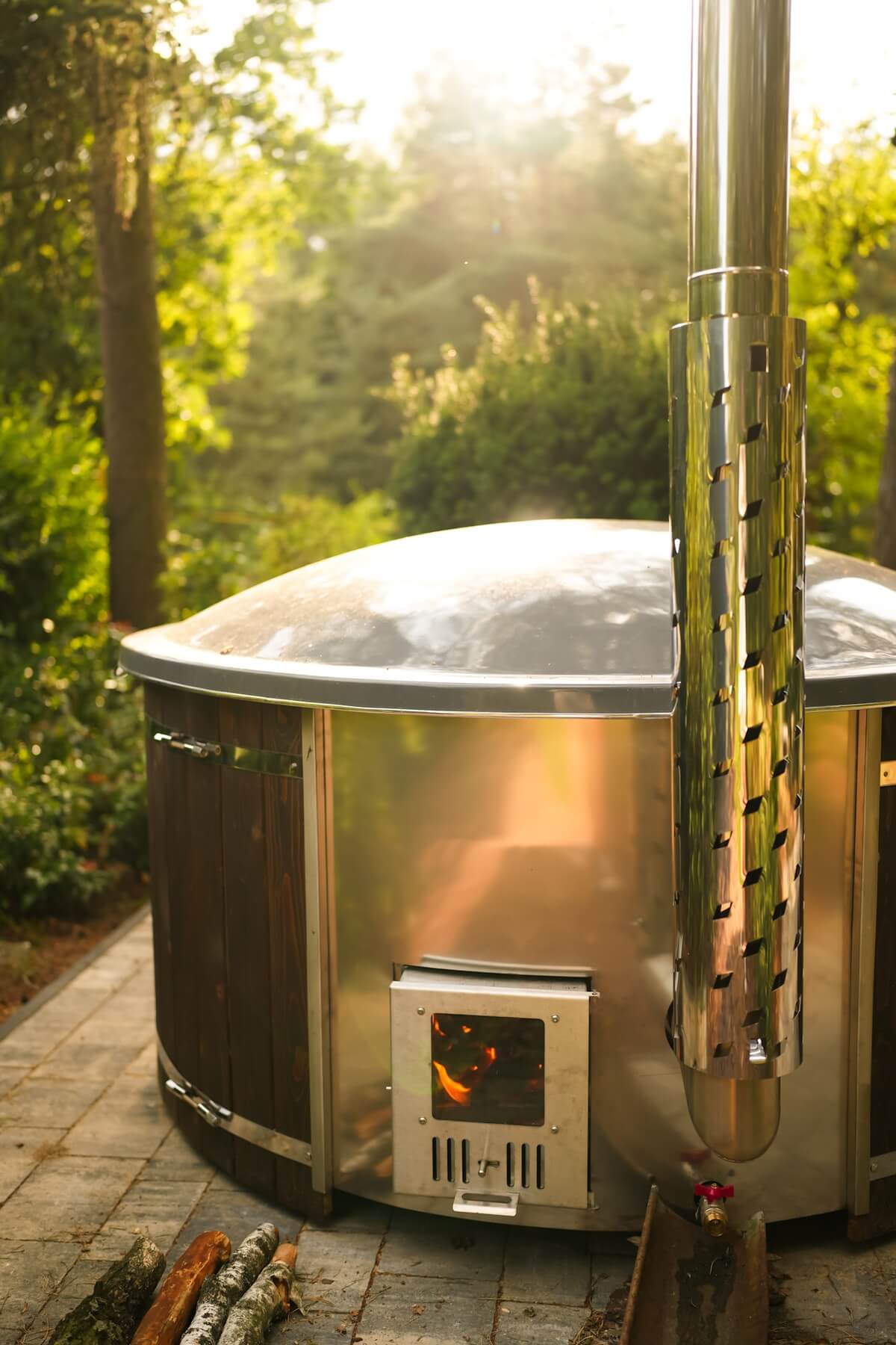 Drewniana balia w ogrodzie z zewnętrznym piecem z rozpalonym ogniem