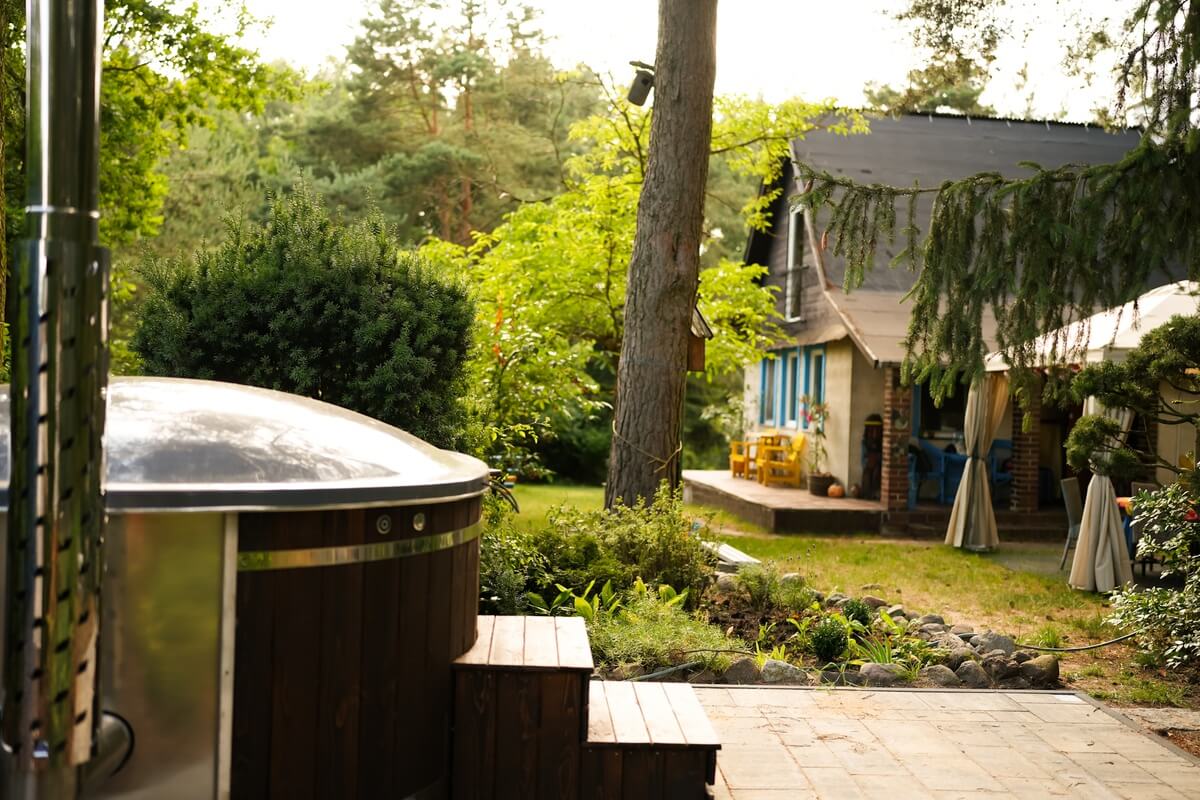 Drewniana balia w zielonym ogrodzie obok domku Villa Isabel