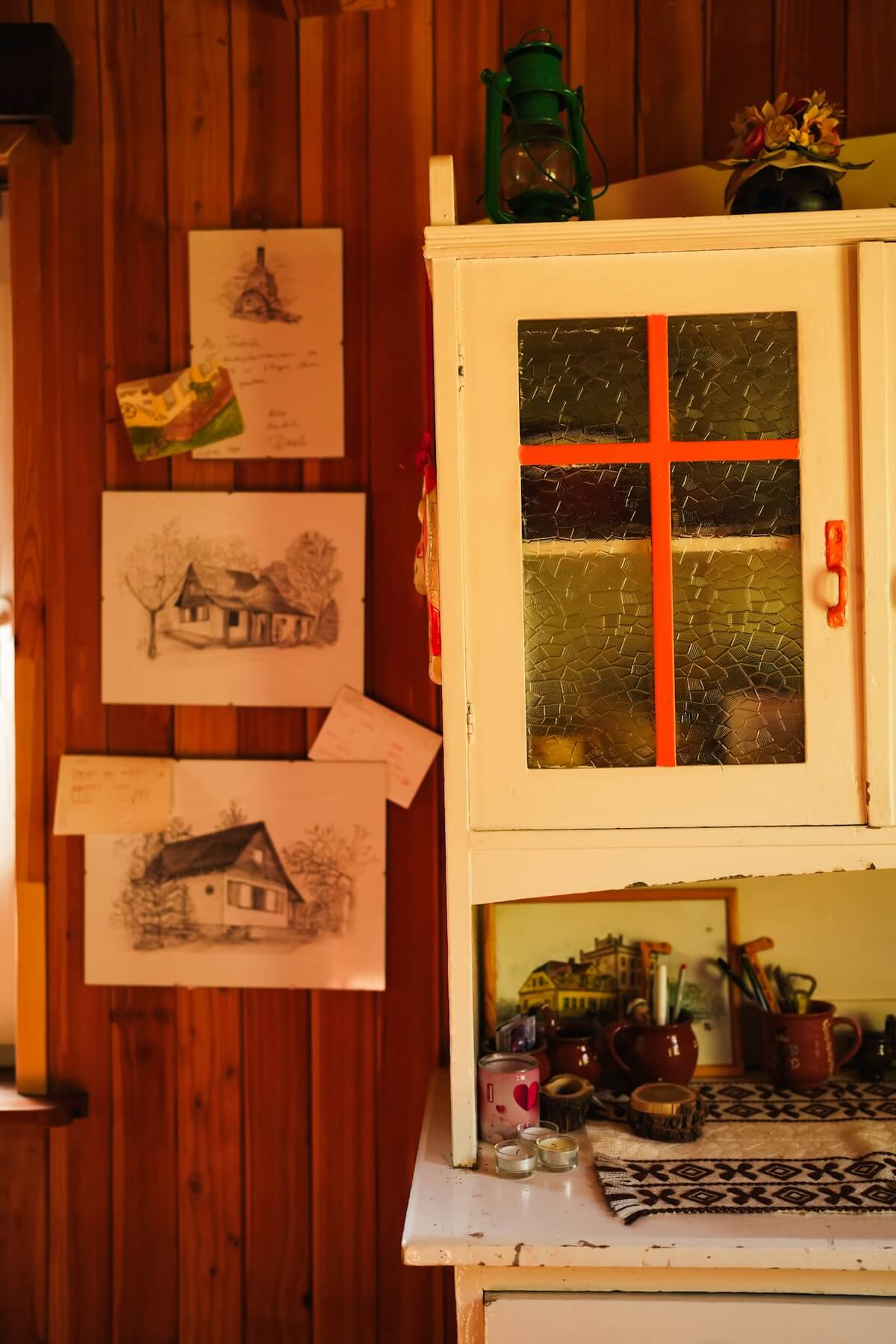 Szkice domku Villa Isabel wykonane ołówkiem na białej kartce papieru wiszące we wnętrzu domku na drewnianej ścianie